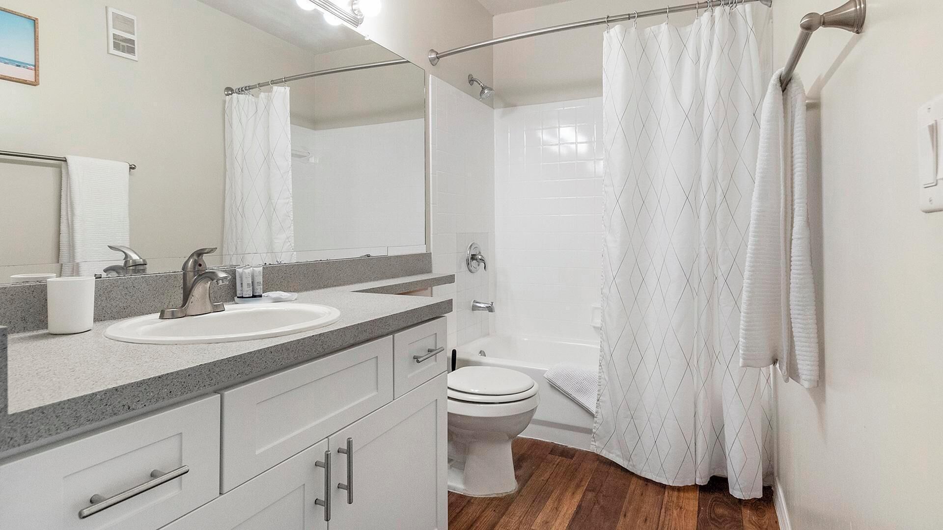 A bathroom with a double sink, a toilet, and a shower.