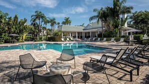A pool area with lounge chairs and a building in the background. - Landing | Incredible 2BD, Game Room, Gym (Longboat Key)