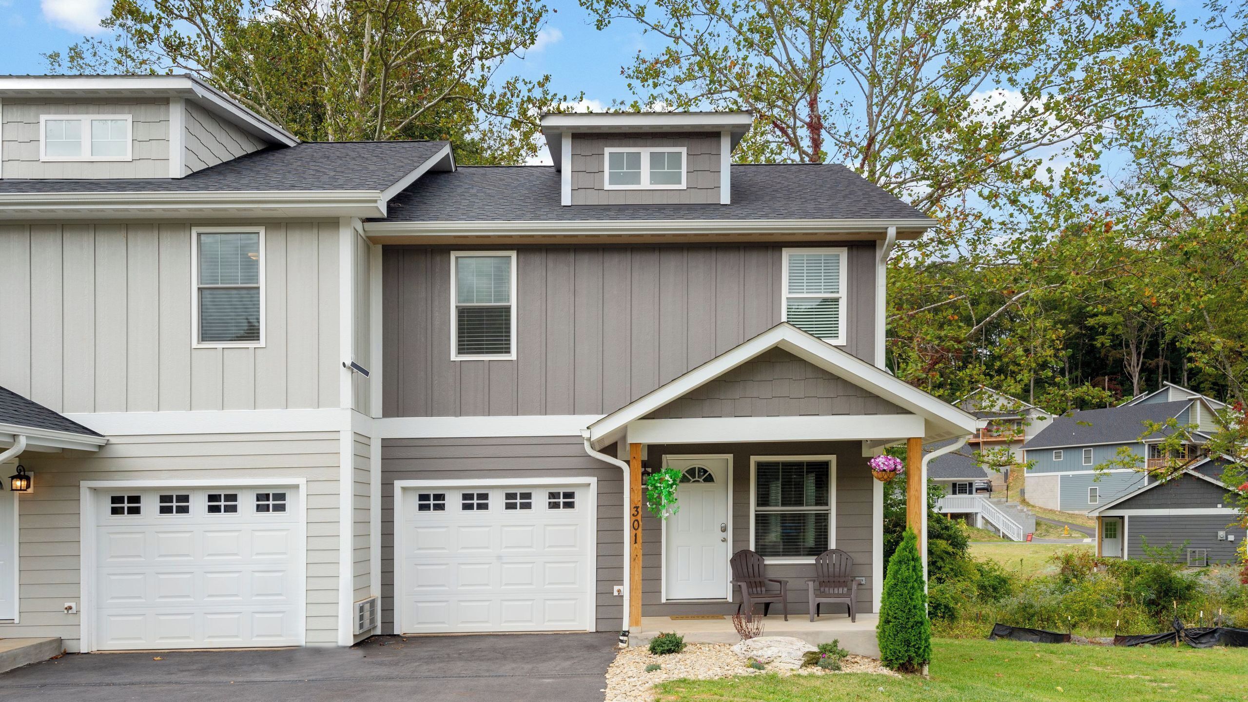 A two-story house with a garage, a covered porch, and a small front yard.