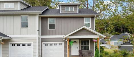 A two-story house with a garage, a covered porch, and a small front yard.