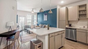 Una cocina moderna con armarios de madera, una isla central e iluminación colgante.