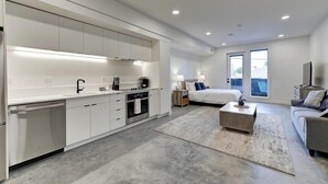 A modern apartment with a kitchen, living area, and bedroom.