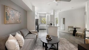 A modern living room with a sofa, coffee table, and artwork on the wall.