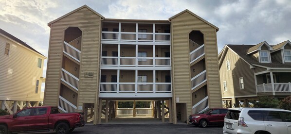 A multi-story building with a central entrance and balconies.