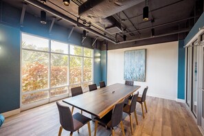 A conference room with a long table, chairs, large windows, and a painting on the wall. - Landing | Spectacular Studio, Pool, Yoga Studio (St. Petersburg)