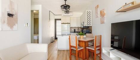 A modern apartment with a living room, dining area, and kitchen.