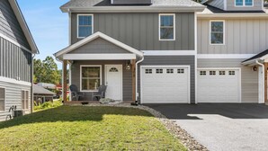 A two-story house with a front porch, a garage, and a well-maintained lawn. - Cypress Sycamore by Avantstay 6 Mins to Downtown (Asheville)