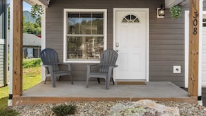 A porch with two chairs, a white door, and a window. - Cypress Sycamore by Avantstay 6 Mins to Downtown (Asheville)