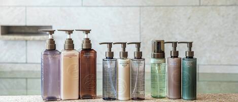 Une rangée de produits de toilette est disposée sur un comptoir en granit.