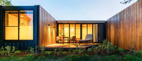 Une maison moderne et compacte dotée d’une terrasse et d’un espace salon extérieur.