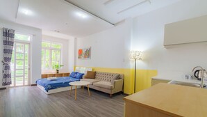 Una moderna camera d'albergo con un letto, un divano e un piccolo tavolo da pranzo.