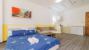 Una camera da letto con un letto, un divano, un tavolino rotondo e un quadro appeso al muro.