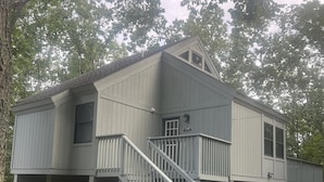 A two-story house with a staircase leading to a balcony.