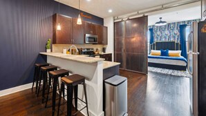 Una cocina moderna con barra, armarios de madera y un microondas integrado.