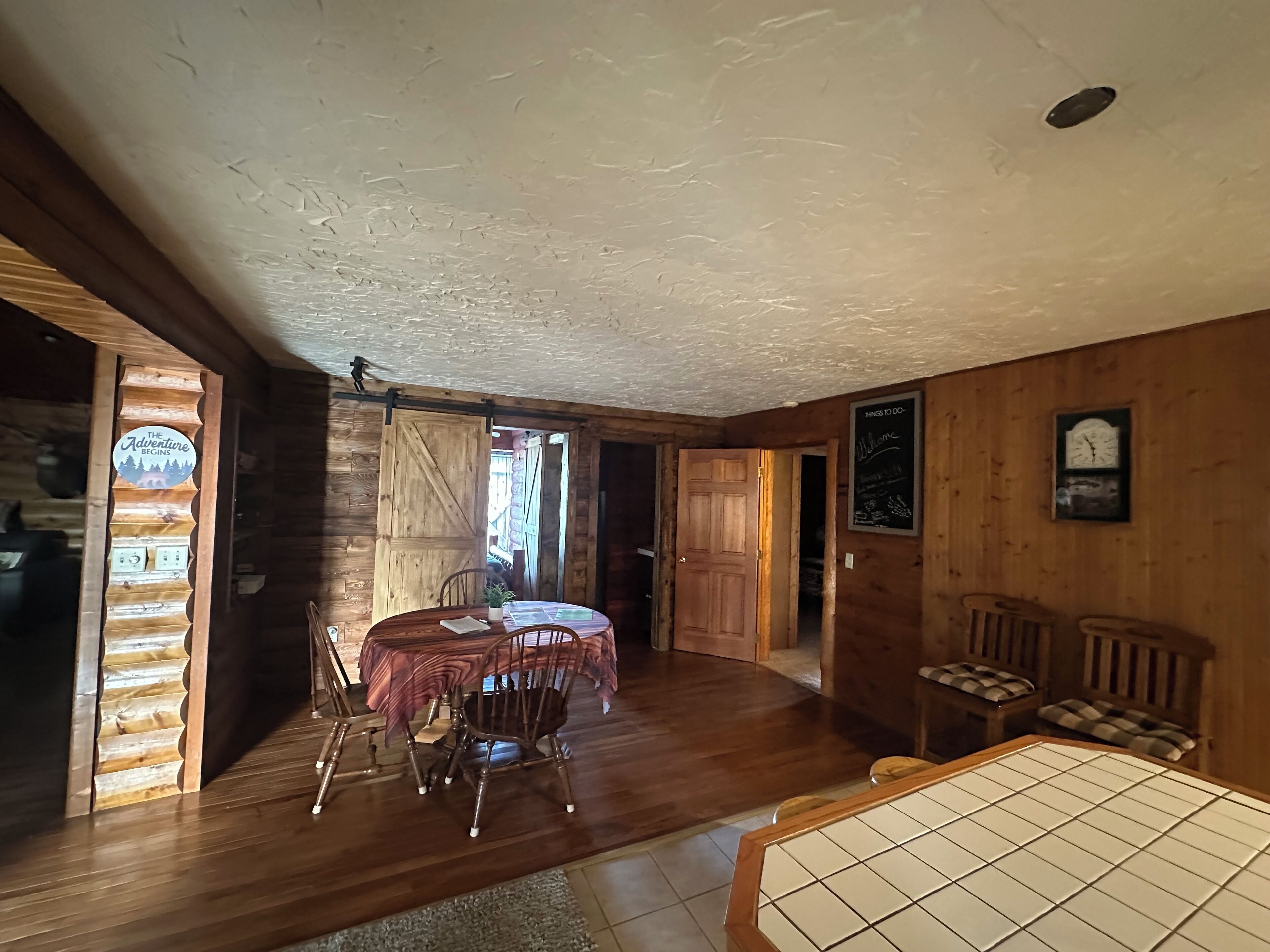 Un interior de madera con una mesa de comedor, sillas y una zona de cocina.