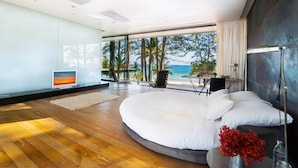 A modern bedroom with a large bed, a TV, and a view of the ocean. - At Last You and Your Friends Can Rent a Luxury Villa with 24/7 Concierge (Chang Wat Phang-nga)