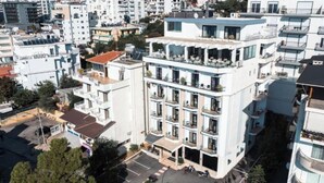 A multi-story building with balconies, a parking lot, and surrounding residential buildings. - New Heaven (Sarandë)