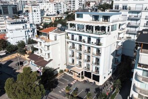 A multi-story building with balconies, a parking lot, and surrounding residential buildings. - New Heaven (Sarandë)