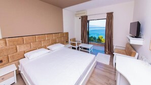 A hotel room with a large bed, a desk, a chair, and a TV. - New Heaven (Sarandë)