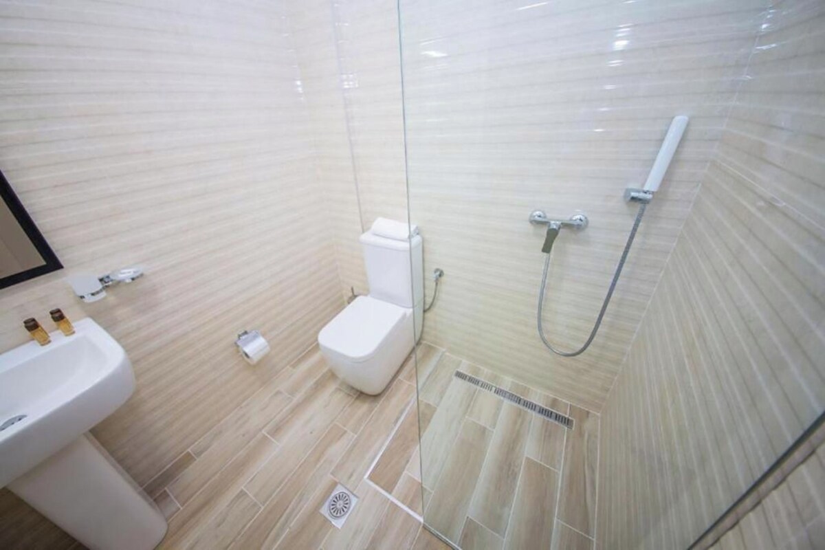 Une salle de bain avec des toilettes, un lavabo et une douche.