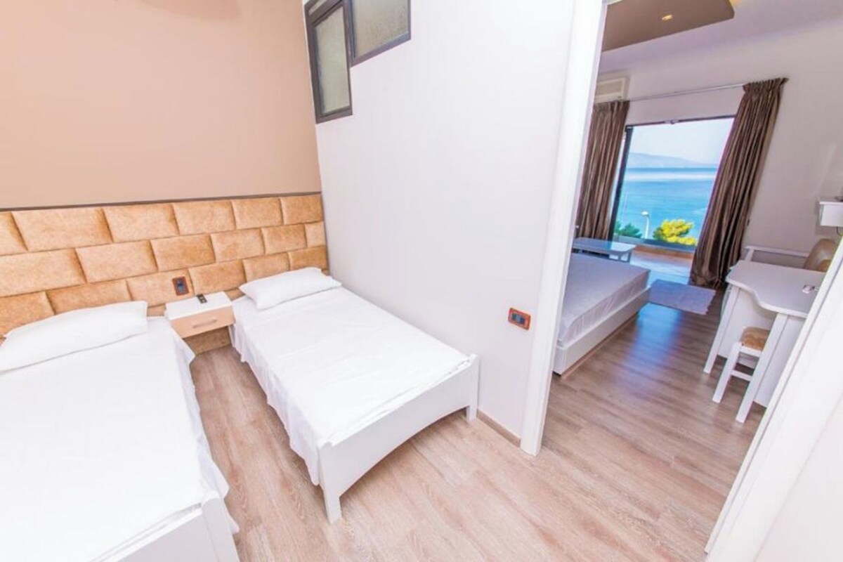 Ein Hotelzimmer mit Bett, Schreibtisch und Meerblick.
