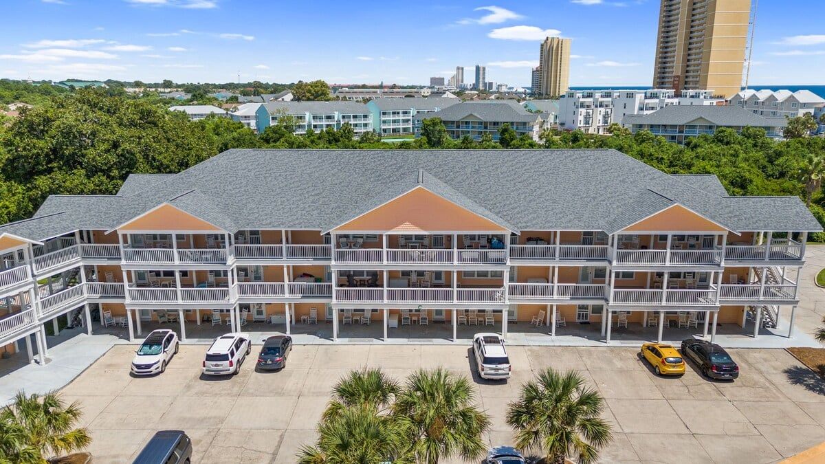 A multi-story hotel with a central courtyard, balconies, and a parking lot.