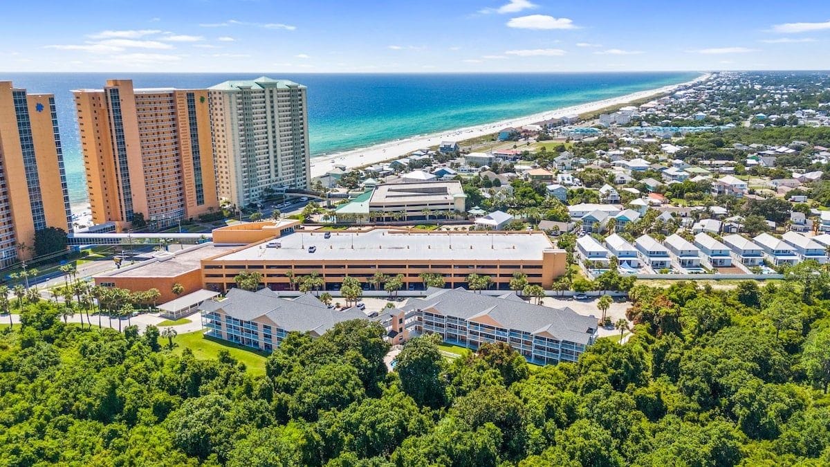 A coastal resort with high-rise buildings, a beach, and a mix of residential and commercial structures.