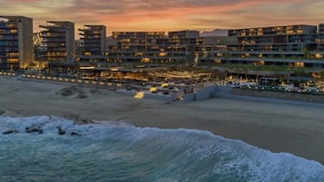 En la playa, playa de arena blanca y camas de playa (con cargo)