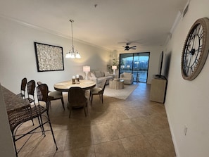 A dining area with a round table, chairs, and a ceiling fan.