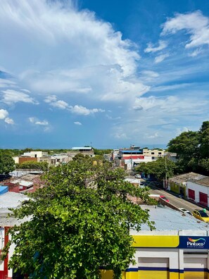 A view of a cityscape with buildings, a clear sky, and a tree in the foreground. - Hotel Buenavista Valledupar (Valledupar)