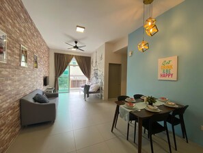 A modern living room with a grey sofa, a dining table set for four, and a ceiling fan. - Cameron Golden Hill Near Night Market CH1 (Brinchang)