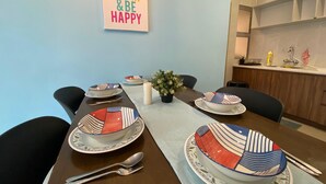 A dining table set with colorful bowls, plates, and cutlery, a candle, and a potted plant. - Cameron Golden Hill Near Night Market CH1 (Brinchang)