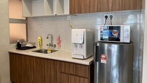 A kitchen with a stainless steel refrigerator, a microwave, a water dispenser, and a sink. - Cameron Golden Hill Near Night Market CH1 (Brinchang)