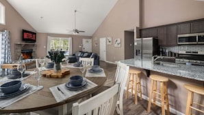 A modern kitchen with dark cabinets, a stainless steel refrigerator, and a granite countertop.