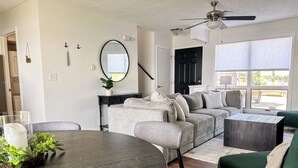 Un salon comprenant un canapé, une table basse et une table à manger avec des chaises.