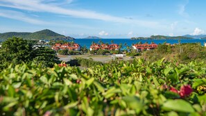 Ein Küstenort mit mehreren Gebäuden mit roten Dächern, einem Strand und üppiger Vegetation.
