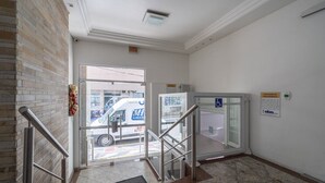 Ein Hotelzugang mit Glastür, Metalltreppe und Backsteinwand.