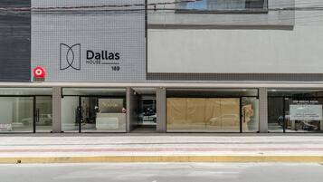 A commercial building with a large sign for 'Dallas House' and a storefront with a 'Conexa' sign.