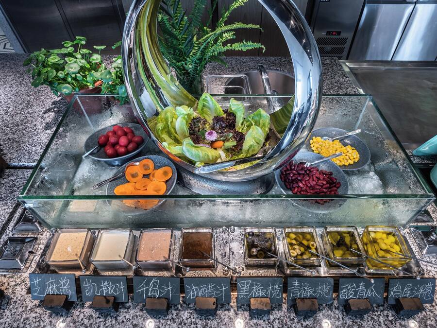 Buffet com diversos pratos e um arranjo decorativo.