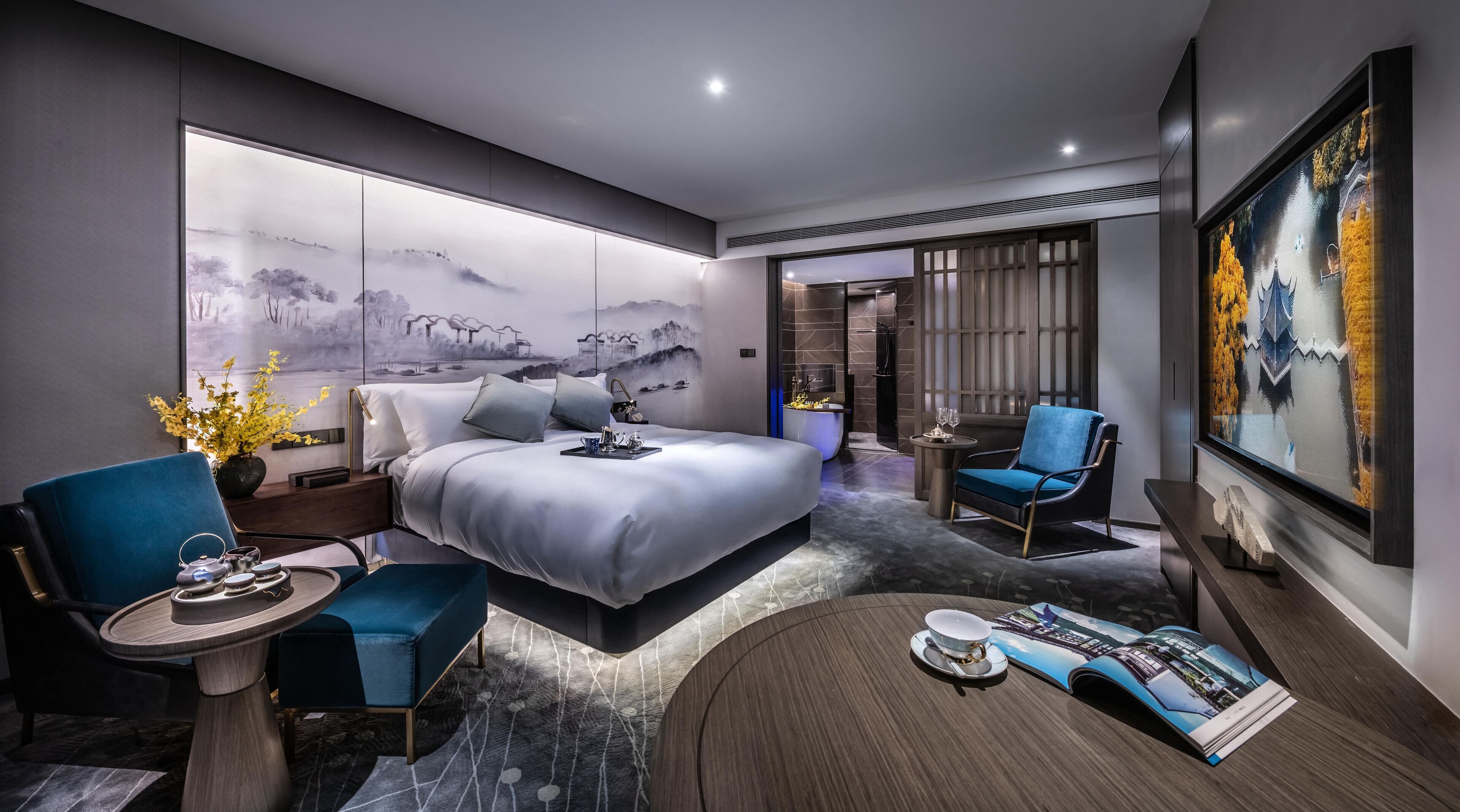 Une chambre d’hôtel moderne dotée d’un grand lit, d’un coin salon avec une table et d’un téléviseur.