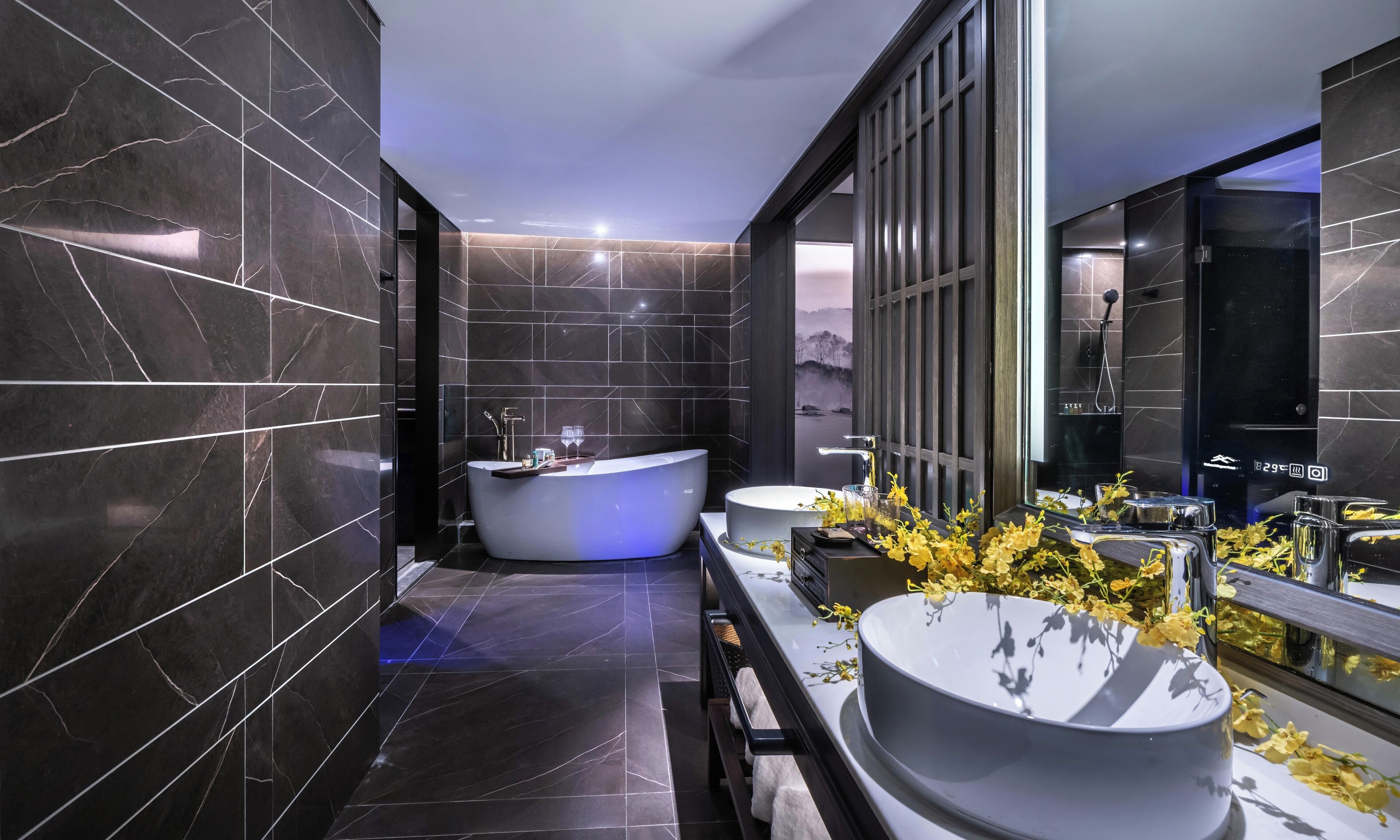 Ein modernes Badezimmer mit einer freistehenden Badewanne, einem Waschtisch mit großem Spiegel und einem Waschbecken.