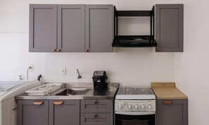 A compact kitchen with grey cabinets, a built-in oven, and a coffee maker. - Beachfront apt BC Center Close to Attract. Eal0704 (Balneário Camboriú)