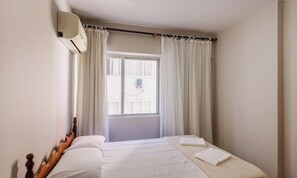 A bedroom with a bed, curtains, a window, and an air conditioning unit. - Beachfront apt BC Center Close to Attract. Eal0704 (Balneário Camboriú)