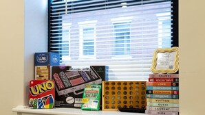 Prestatgeries amb diversos objectes, incloent UNO, Monopoly i llibres.