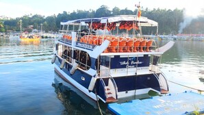 Um grande navio de cruzeiro com um deque superior coberto e um deque inferior com assentos.