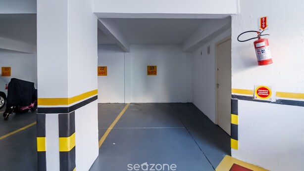 Un couloir avec des portes numérotées, un extincteur et un panneau indiquant un espace réservé aux fumeurs.