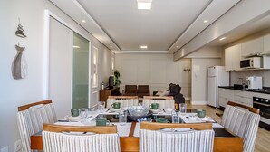 A modern kitchen with white cabinets, a microwave, and a refrigerator.