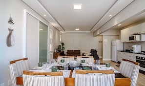 A modern kitchen with white cabinets, a microwave, and a refrigerator.