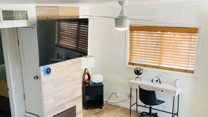 A compact living space with a kitchenette, a dining area, and a workspace.