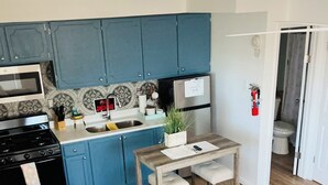 A compact living space with a kitchenette, a dining area, and a sofa.